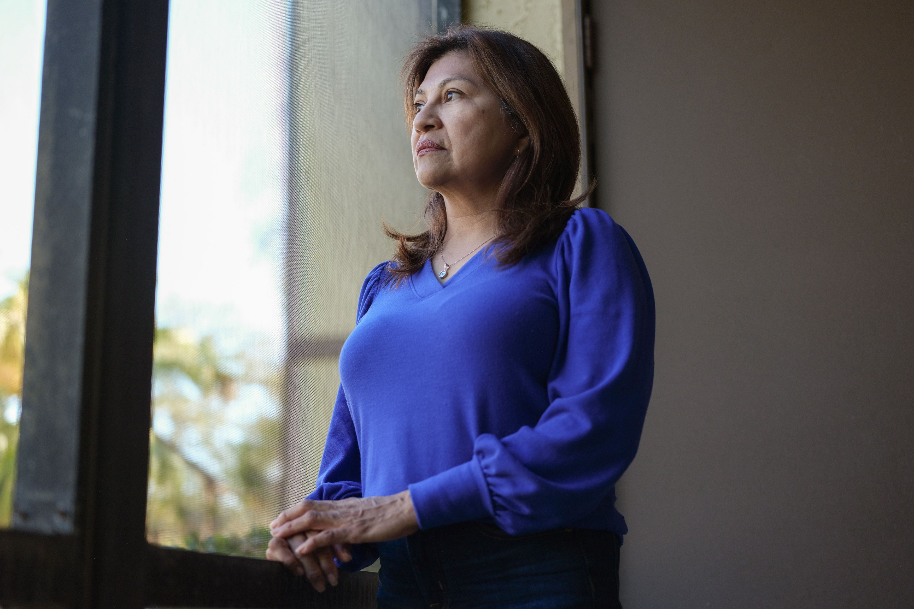 Lorena Alvarado Hill stands for a portrait indoors. She is looking out the window.