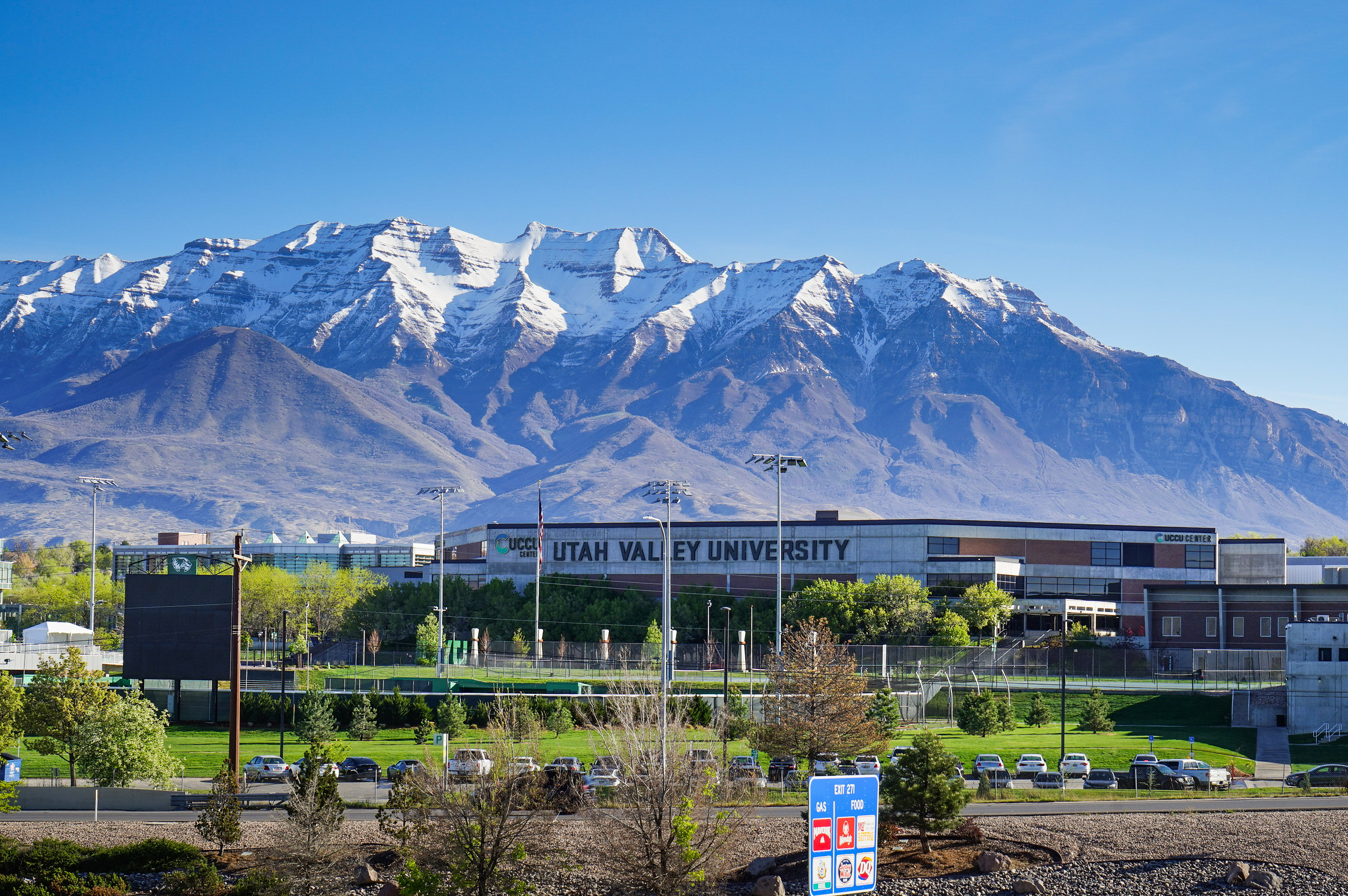 An exterior shot of a Utah Valley University building with mountains seen behind it.