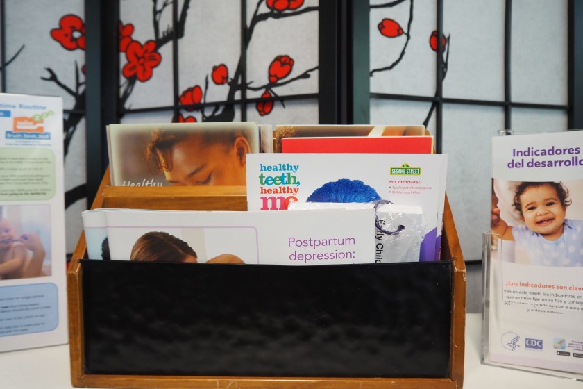 Pamphlets, including ones about postpartum depression, are displayed on a tabletop