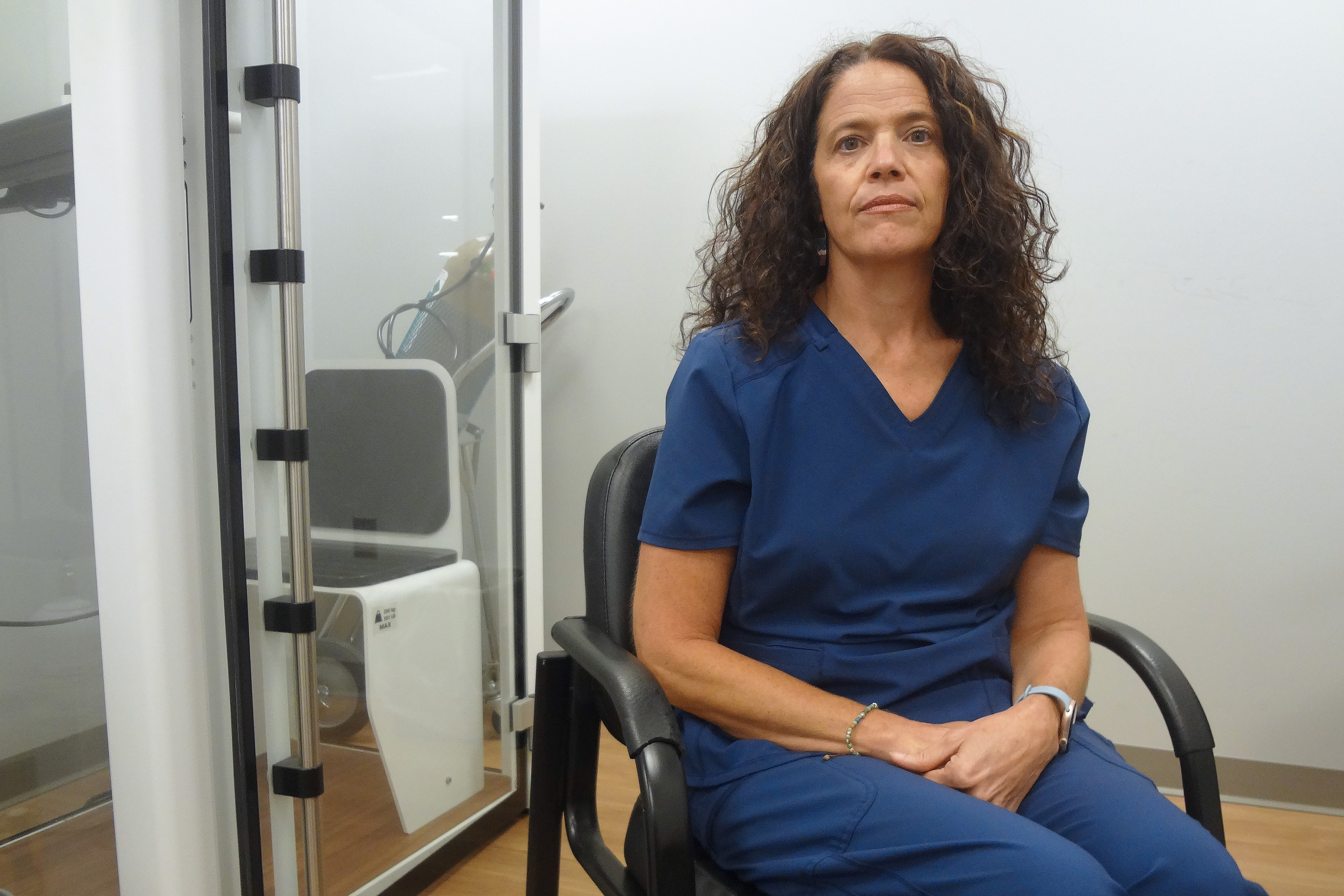 A photo of Lisa Emery seated indoors at a health clinic.
